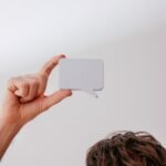 Close-up of a person holding a white speech bubble mockup against a white background.